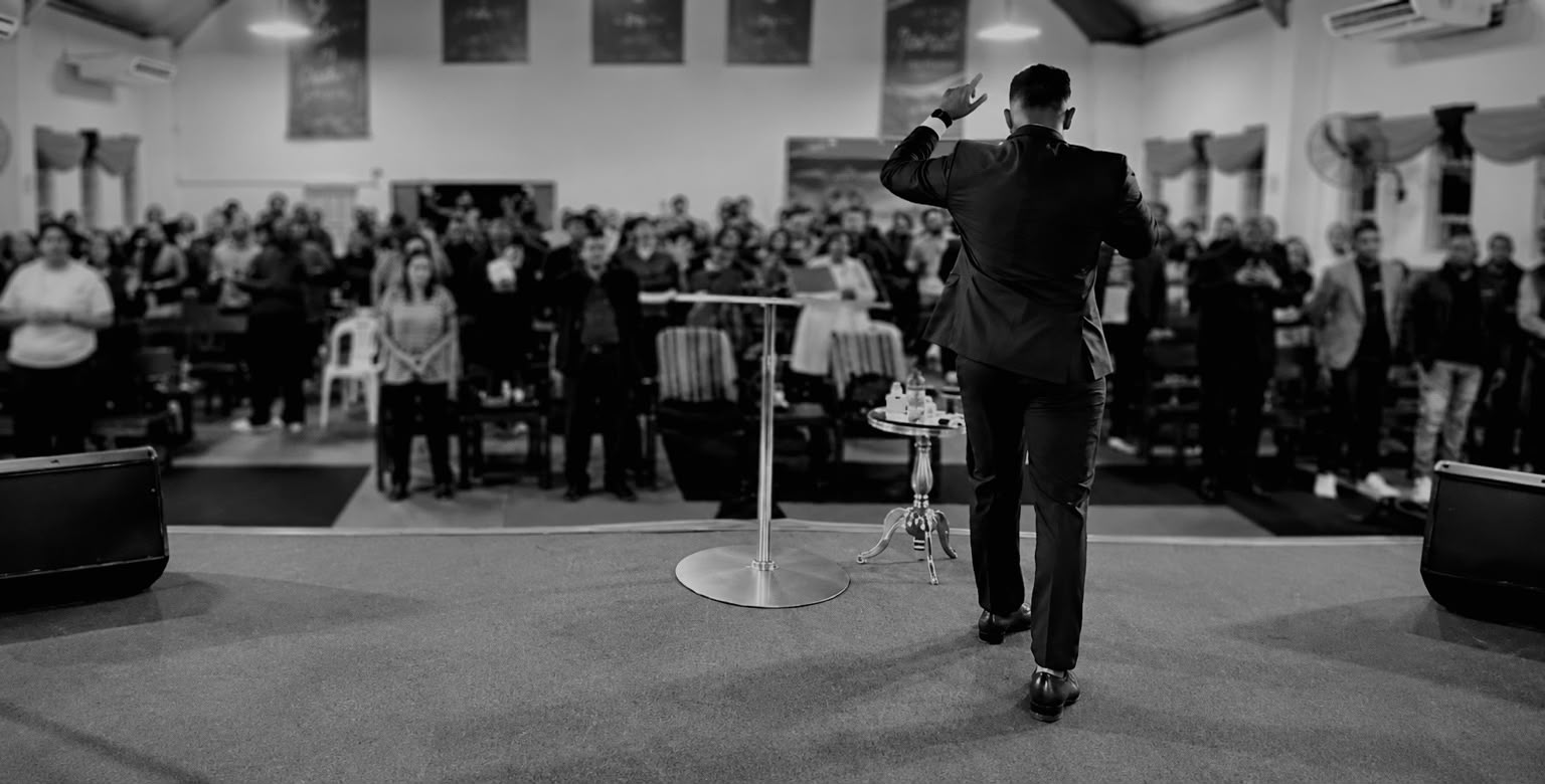 Avishek Busviah on stage addressing a large audience
